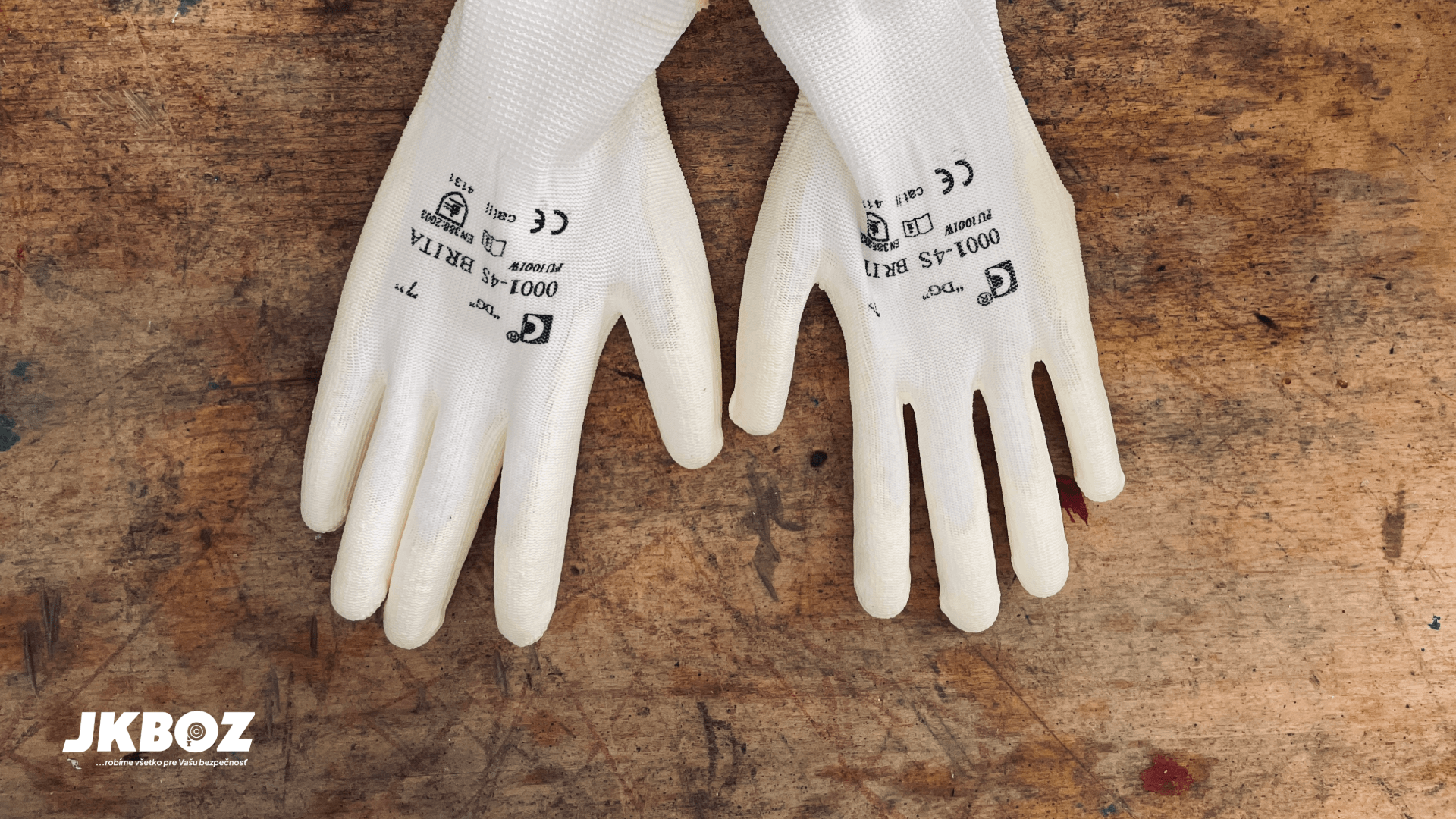 Ochranné pracovné rukavice položené na pracovnom stole.